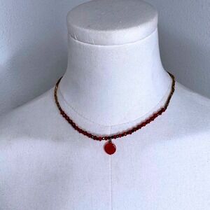 Red and gold beaded choker with drop charm pendant